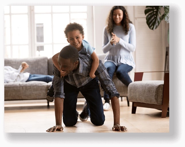 image showing joyful man in no pain with his young son riding on his back